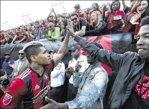  ?? CURTIS COMPTON / CCOMPTON@AJC.COM ?? Atlanta United forward Josef Martinez gets a big high-five after scoring two goals against the Chicago Fire on Saturday. Martinez has scored five goals in the Five Stripes’ past two games.
