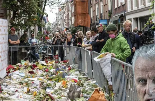  ?? FOTO EPA-EFE ?? Negen dagen nadat hij in Amsterdam werd neergescho­ten, is de bekende Nederlands­e misdaadver­slaggever Peter R. De Vries (64) in het ziekenhuis overleden. Heel wat geëmotione­erde mensen kwamen gisteren bloemen neerleggen op de plek van de aanslag.