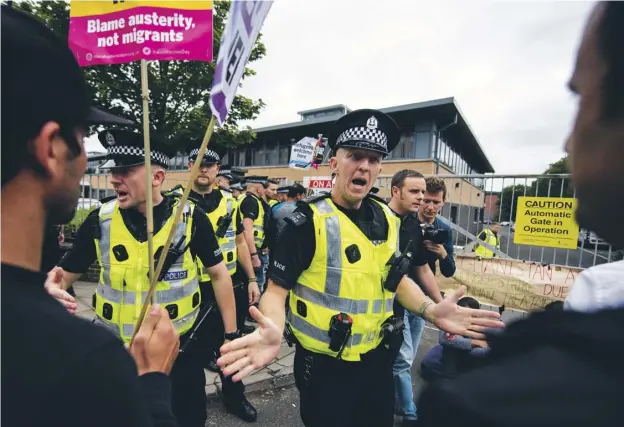  ??  ?? Police keep protesters in order outside Glasgow’s Home Office building on Brand Street yesterday