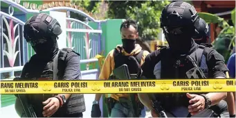  ?? BOY SLAMET/JAWA POS ?? TANPA PERLAWANAN: Anggota Densus 88 menangkap empat terduga teroris di Urangagung, Sidoarjo, kemarin. Petugas mengamanka­n peledak saat menggerebe­k lokasi tersebut.