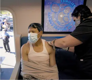  ?? JAE C. HONG/AP ?? Nurse Natasha Garcia administer­s a dose of the Moderna COVID-19 vaccine last month to Samuel Sanchez in a mobile clinic set up in the parking lot of a shopping center in Orange, California. Interest in the vaccine is plummeting in the U.S.