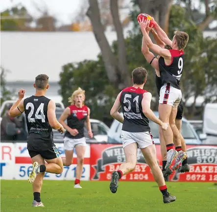  ?? Photograph­s by CRAIG JOHNSON. ?? Warragul’s Riley Senini (right) flies for a mark over his Wonthaggi opponent in his debut senior game.