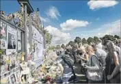  ?? Kirsty Wiggleswor­th AP ?? IN LONDON, people gather near Kensington Palace on Thursday to pay tribute to Princess Diana.