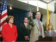  ?? ERIC RISBERG-ASSOCIATED PRESS ?? In this June 29, 2004, file photo, Steve Sposato, who lost his wife in a shooting, holds an automatic rifle as Sen. Dianne Feinstein, D-Calif., left, then San Francisco Mayor Gavin Newsom, second left, and Sen. Barbara Boxer, D-Calif., right, look on at a news conference in San Francisco.