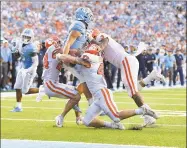  ?? Grant Halverson / Getty Images ?? Clemson’s Nolan Turner (24), James Skalski (47) and Xavier Thomas (3) stop North Carolina’s Sam Howell short of the goal line on a twopoint conversion in the final minute of the Tigers’ 2120 victory on Saturday.