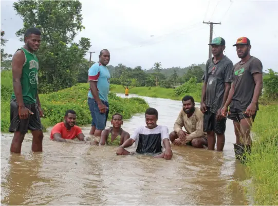  ?? Photo: Simione Haravanua ?? Youths from Naqali Village in Naitasiri at a flooded road on December 29, 2018.