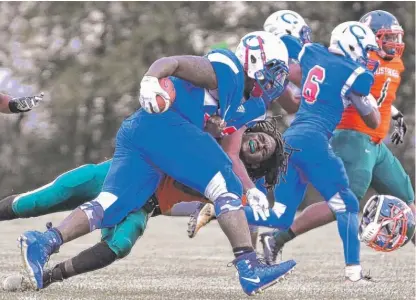  ??  ?? Curie running back AJ Sanya knocks Tyler Moore’s helmet off in the third quarter Thursday. | WORSOM ROBINSON/ FOR THE SUN- TIMES