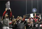  ?? AP PHOTO / JAE C. HONG ?? Boston Red Sox manager Alex Cora holds the championsh­ip trophy after Game 5 of baseball's World Series against the Los Angeles Dodgers on Sunday.