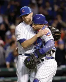  ?? The Canadian Press ?? Cubs pitcher Wade Davis and catcher Willson Contreras celebrate after Game 4 of baseball’s National League Championsh­ip Series against the Los Angeles Dodgers, Wednesday, in Chicago. The Cubs won 3-2.