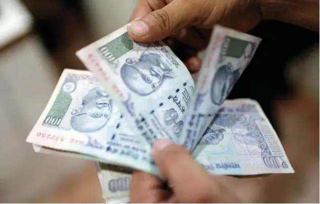  ?? File/ Reuters ?? ↑
An employee counts Indian rupee currency notes inside a private money exchange office in New Delhi.