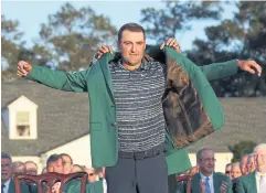  ?? AFP ?? Scottie Scheffler receives his green jacket after winning the Masters.