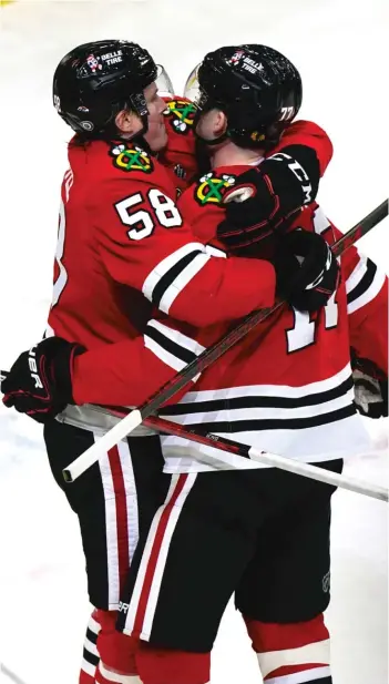  ?? NAM Y. HUH/AP ?? Blackhawks center Kirby Dach (right) celebrates with right wing MacKenzie Entwistle after scoring a goal against the Predators in the first period Friday night at the United Center.