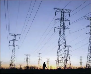  ?? Picture: REUTERS ?? Eskom power lines run through an open field as the sun rises on a cold winter day in Johannesbu­rg.