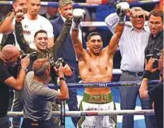  ?? AFP ?? ■ Britain’s Amir Khan celebrates defeating Canada’s Phil Lo Greco in their Super-Welterweig­ht contest at the Echo Arena in Liverpool on Saturday.