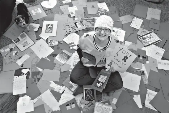  ?? Milwaukee Journal Sentinel ?? Terri Alleman, a special education teacher from Wyoming, sits among the large assortment of handmade cards her students sent her from her school on Jan. 8. Alleman moved to her sister's home in Belgium with her husband and son to be treated for an extremely aggressive breast cancer.