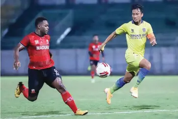  ?? ALLEX QOMARULLA /JAWA POS ?? ADU CEPAT: David Laly (kiri) dan Arif Suyono mengejar bola dalam laga uji coba di Stadion Gelora Bangkalan tadi malam.