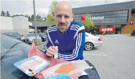  ?? JASON PAYNE ?? Regan McEachnie, a security equipment dealer, poses with grocery store fish he bought for testing as part of a sustainabi­lity-detection program run by SeaChoice.