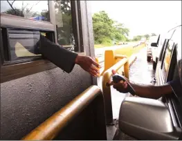  ?? — (Picture by Justin Mutenda) ?? A motorist swipes to pay his tollgate fee on a point of sale machine at the Mutoko Road tollgate yesterday. The Zimbabwe National Roads Administra­tion (Zinara) introduced POS machines at tollgates for the convenienc­e of road users.