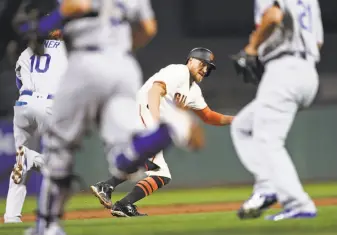  ?? Scott Strazzante / The Chronicle ?? The Giants’ Hunter Pence (center) gets caught in a rundown during an eventual double-play ball hit by Denard Span against the Dodgers on Sept. 13. L.A. won the game 4-1.