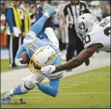  ?? Associated Press ?? NOT QUITE THERE — Oakland Raiders cornerback Daryl Worley, right, tackles Los Angeles Chargers wide receiver Keenan Allen short of the goal line during the second half on Sunday in Carson.