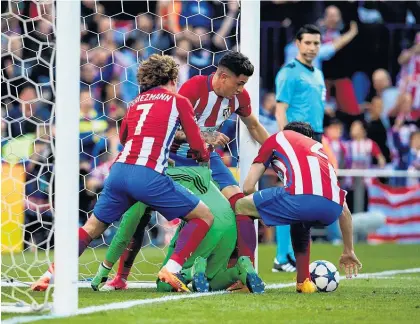  ??  ?? Atletico Madrid players scramble to score against Real Madrid yesterday.