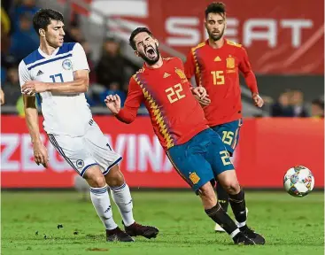  ??  ?? Painful: Spain midfielder Isco grimaces as he vies with Bosnia defender Ervin Zukanovic during the friendly in Las Palmas on Sunday. —AFP