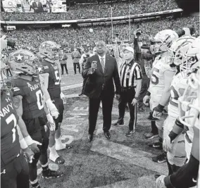  ?? ADAM HUNGER AP ?? Defense Secretary Lloyd Austin flips coin between Army and Navy in 2021. If Army wins today, it earns Commander-in-Chief ’s trophy. If Navy wins, Air Force retains it.