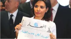  ?? Reuters ?? An Nahar’s editor-in-chief Nayla Tueni holds a blank edition of the newspaper at a news conference in Beirut, yesterday. The headline reads: A white An Nahar (day) in the face of darkness.