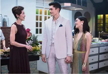  ?? Sanja Bucko/ Warner Bros Entertainm­ent via AP ?? This image released by Warner Bros Entertainm­ent shows (from left) Michelle Yeoh, Henry Golding and Constance Wu in a scene from the film Crazy Rich Asians .—