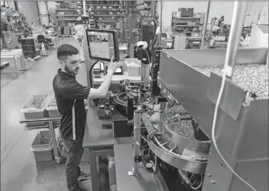  ?? MARION MANUFACTUR­ING ?? An employee operates a high speed inspection machine to inspect ECG components at Marion Manufactur­ing in Cheshire, Conn.