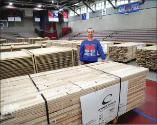  ?? Photo by Ernest A. Brown ?? Mount St. Charles boys basketball coach Henry Coleman stands among pallets of wood Saturday as the school begins the process of laying down a hardwood floor in the gymnasium.