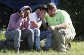  ?? THE ASSOCIATED PRESS ?? Workers from the Advanced Granite Solutions company console each other as police and Emergency Medical Services respond to the shooting at a business park in the Edgewood area of Harford County, Md., on Wednesday.
