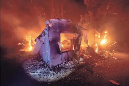  ?? NOAH BERGER/AP ?? Flames from the LNU Lightning Complex Fire consume a home in unincorpor­ated Napa County, Calif., on Wednesday. Fire crews across the region scrambled to contain dozens of wildfires sparked by lightning strikes.