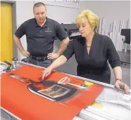  ??  ?? Linda McMahon of the SBA discusses the problems of getting the color red to print correctly with Ross Portchelle­r, head of the graphics department at Exhibit Solutions of New Mexico, during a tour on Monday.