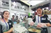  ?? PROVIDED TO CHINA DAILY ?? Attendants cook instant noodles at the COFCO booth during a food safety technology exhibition in Beijing.