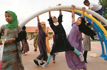  ?? JESSIE WARDARSKI/AP ?? Children play at a park Thursday in the predominan­tly Somali neighborho­od of Cedar-Riverside in Minneapoli­s. The local Dar AlHijrah mosque is one of 12 in the city that have received approval to broadcast the Islamic call to prayer.