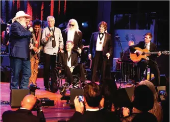  ??  ?? From left, artists Charlie Daniels, Duane Allen, Charley Pride, Joe Bonsall, Randy Travis, William Lee Golden, and Richard Sterban sing ‘Will the Circle Be Unbroken?’ at the close of the Country Music Hall of Fame Medallion Ceremony.