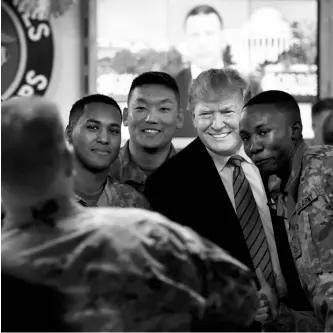  ?? PHOTO: REUTERS ?? Donald Trump poses for a photo with American troops during a surprise visit at Bagram Air Base in Afghanista­n on November 28. It was his first visit to the country since becoming president