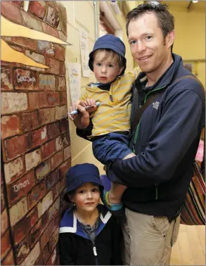  ??  ?? Cameron, Euan and Craig Petrie signing their brick in the new playground.