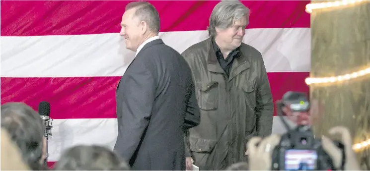  ?? NICOLE CRAINE / BLOOMBERG ?? Steve Bannon, chairman of Breitbart News, welcomes Roy Moore, failed Republican candidate for the U. S. Senate, during a campaign rally in Alabama earlier this month.