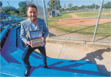  ?? IVY CEBALLO/TAMPA BAY TIMES ?? West Tampa Tobacco Company founder Rick Fernandez with the company’s cigars at the grounds of the West Tampa Little League field. The little league’s symbol inspired his cigar art.