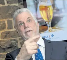  ?? FRANCIS VACHON/THE CANADIAN PRESS ?? Quebec Premier Philippe Couillard talks to the press in a Quebec City pub on Wednesday. Couillard discussed a new legislatio­n on liquor laws.