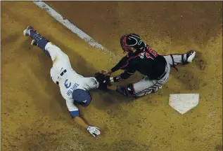  ?? DAVID J. PHILLIP — THE ASSOCIATED PRESS ?? The Dodgers’ Chris Taylor is tagged out at home by Braves catcher Travis d’Arnaud during the sixth inning in Game 7 of the NLCS on Sunday night in Arlington, Texas. The Dodgers won 4-3 to reach the World Series.