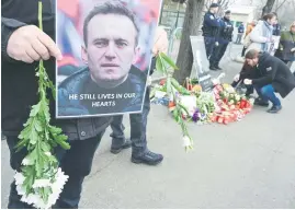  ?? Picture: AFP ?? MOURNING. People pay tribute to Kremlin critic Alexei Navalny at the Russian embassy in Bucharest, Romania. His supporters accuse authoritie­s of ‘covering their tracks’ by not handing over his body.