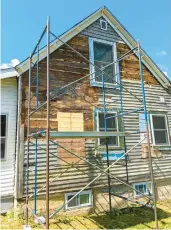  ?? TIM CARTER/TNS ?? Safe pipe scaffoldin­g allows these homeowners to install new vinyl siding themselves.