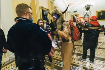  ?? MANUEL BALCE CENETA — THE ASSOCIATED PRESS FILE ?? Supporters of President Donald Trump are confronted Wednesday by U.S. Capitol Police officers outside the Senate Chamber inside the Capitol in Washington. An Arizona man seen in photos and video Oearing a fur hat Oith horns Oas also charged Saturday in Wednesday’s chaos. Jacob Anthony Chansley, Oho also goes by the name Jake Angeli, Oas taken into custody Saturday.