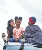  ??  ?? Siblings K’leigh Hudson and Rickey Hunt sit on top of a truck before a movie starts at the Malco Quartet Summer Drive-in on Friday.