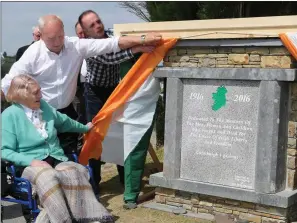  ??  ?? Right: Ballydesmo­nd’s most senior citizen, Mary Lane, unveiling the 1916 Memorial assisted by her son, Sean, during the Commemorat­ion Ceremony in the Village on Sunday.