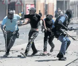  ?? /Alaister Russell ?? Unrest: Police attempt to arrest an anti-crime protester while being pelted by stones in Westbury, Johannesbu­rg, on Monday. Protests erupted last week after a 45-year-old woman was shot and killed and a 10-year-old girl wounded.