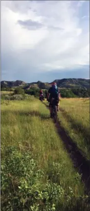  ?? CAREY J. WILLIAMS — THE ASSOCIATED PRESS ?? Ryan Johnson leading Drew Redman on the single-track trail that makes the Maah Daah Hey Trail, in western North Dakota, a popular destinatio­n for mountain bikers.